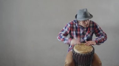 Bıyıklı, şapkalı, etnik davul çalan komik bir adam. Etnik davul çalan beyaz müzisyen. Hippi, Tom-Tom 'da etnik müzik çalıyor. Yapıştırıcı kopyala