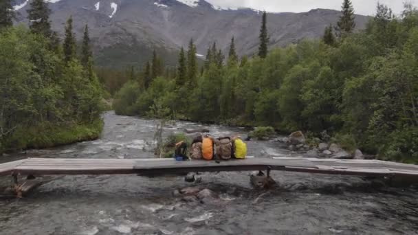 Utazási koncepció. Négy túrázó barát öleli meg egymást, hátulról nézve a hegyet - szeretik a szabadságot és az emberek iránti vágyat. — Stock videók