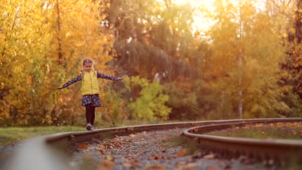 Cute little girl walking on the train tracks — Stock Video