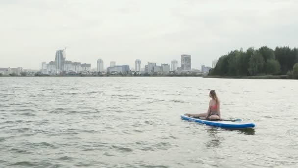 Ung kvinna på en måltavla. Stadsbild på bakgrunden. — Stockvideo