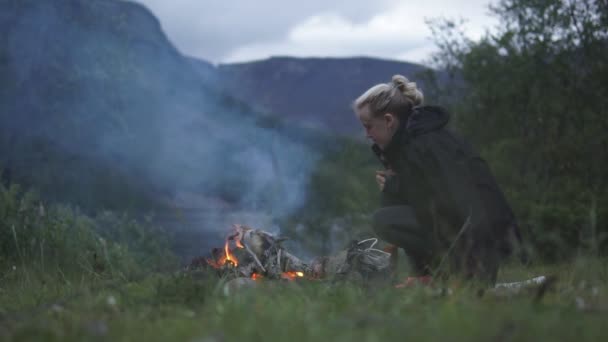 Jong meisje probeert warm te blijven bij het vuur — Stockvideo