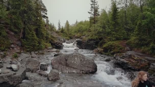 Doğada dinlenen bir gezgin Dağlardaki bir nehrin kıyısında — Stok video