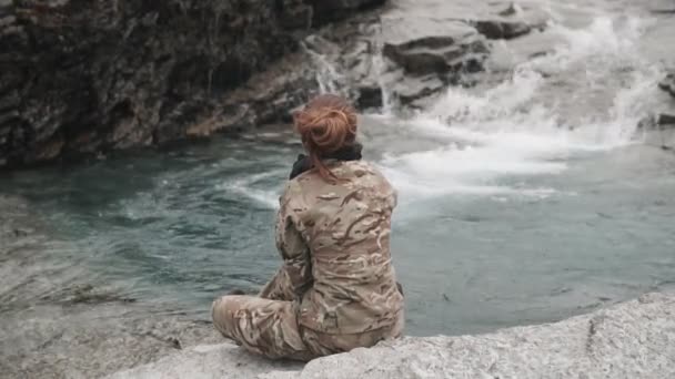 Reiziger rustend in de natuur aan de oevers van een rivier in de bergen — Stockvideo