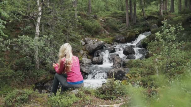 Utazó pihen a természetben a folyó partján a hegyekben — Stock videók