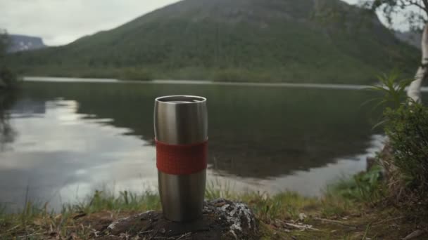 Café ou thé à la vapeur dans une tasse thermo sur la vue sur la montagne en arrière-plan . — Video
