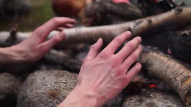 Tourist warming his frozen hands by a fire — Stock Video