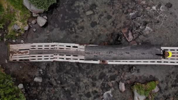 Top view of a group of hikers with large backpacks cross the bridge. — Stock Video