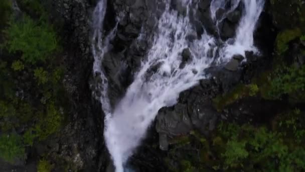 Top view portret van mooie blonde vrouw luisteren muziek op rots in de buurt waterval. — Stockvideo