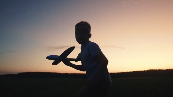 Menino lança avião de brinquedo na natureza — Vídeo de Stock