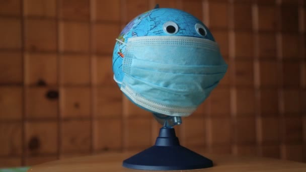 Globe i skyddande medicinsk mask — Stockvideo