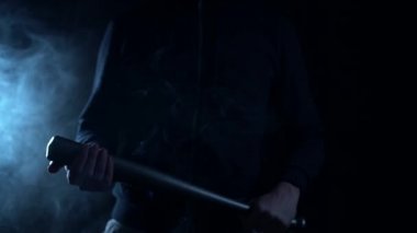 Close up. Street hooligan is holding a baseball bat.