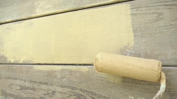 Close up, χέρι σε προστατευτικό γάντι ζωγραφική ξύλινο σπίτι με ρολό — Αρχείο Βίντεο