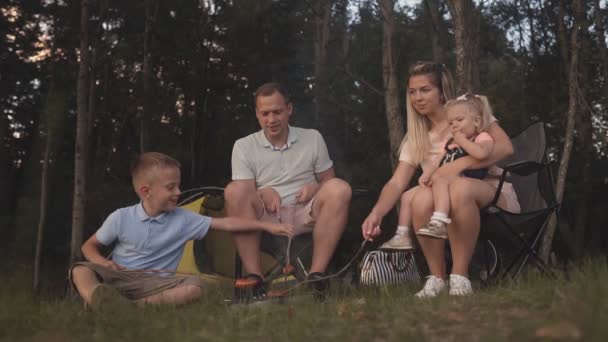 Νεαρή οικογένεια χαλαρωτικό μέσα σε σκηνή για κάμπινγκ διακοπών — Αρχείο Βίντεο