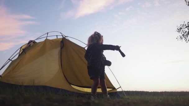 Härlig liten flicka med ficklampa, utomhus läger aktivitet. En liten flicka nära tältet. — Stockvideo