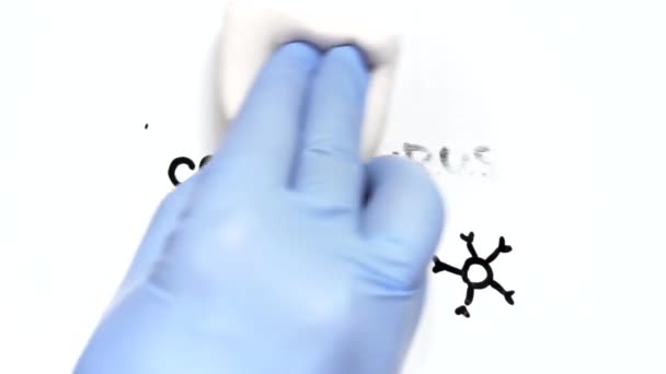 Einde van de epidemie. Een hand in een medische handschoen wist het woord CORONAVIRYS — Stockvideo