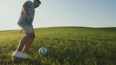 Baba ve oğlu sahada futbol oynuyorlar..