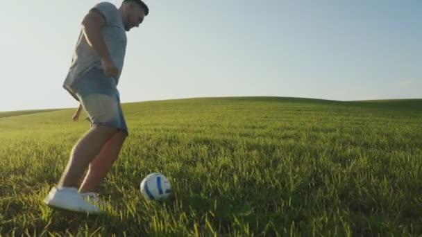 Vader en zijn zoon spelen samen voetbal op het veld. — Stockvideo