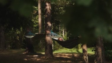 Çekici bir adamın portresi hamakta rahatlar. 