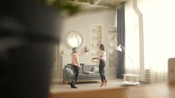Happy carefree girls dance at home while listening to music on the phone. — Stock Video