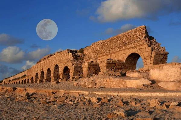 Aqueduct in Caesarea at sunset with a full moon — Stock Photo, Image