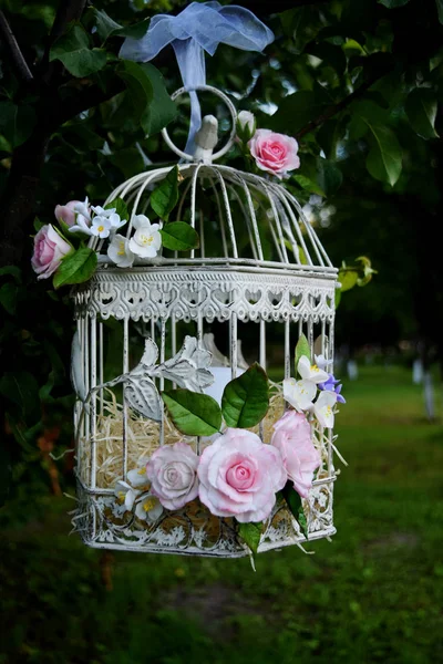 Bird cage with spring blossom flowers. Wedding decorations. Stock Image