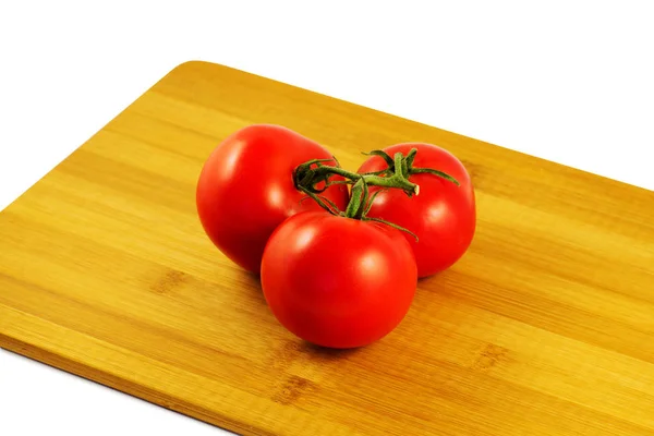 Tomates sobre tabla de madera aislados sobre fondo blanco — Foto de Stock