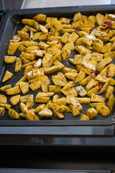 Nära håll varm kryddig potatis med örter på en plåt. — Stockfoto
