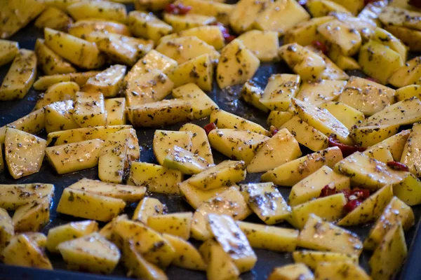 Chiuda la patata piccante calda con erbe su un foglio di cottura al forno . — Foto Stock