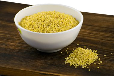 Darı kahverengi tahta üzerinde beyaz kase. Buğday. Sağlıklı Diyet kabuğu çıkarılmış tane arka plan.