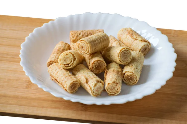 Wafer gulung renyah terisolasi pada latar belakang putih. Wafel viena gulung di piring putih. Wafer rolls in a white plate — Stok Foto