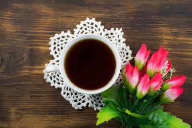 Bir fincan çay ve Pembe Lale ahşap arka plan üzerinde. Bir buket pembe laleler ve bir fincan kahve