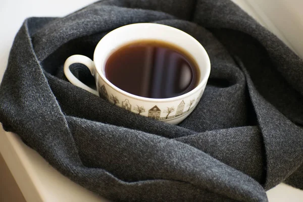 Уютный мягкий серый шарф с чашкой кофе — стоковое фото