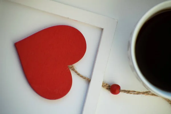 Kopp kärlek, kaffe med rött hjärta. Rött hjärta på ett rep i träram. Alla hjärtans dag. Morgon. Den 14 februari. — Stockfoto