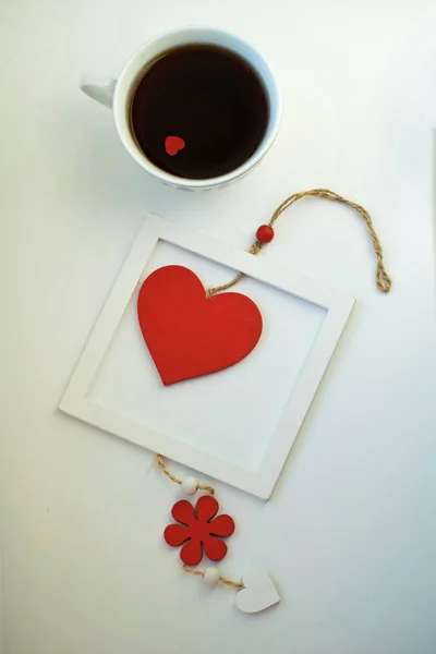 Aşk, kırmızı kalp ile kahve fincan. Kırmızı kalp ahşap çerçeve içinde bir ip üzerinde. Sevgililer günü. Sabah. 14 Şubat. — Stok fotoğraf