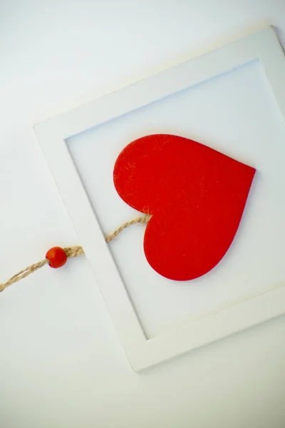 Красное сердце на веревке в деревянной раме. День Святого Валентина . — стоковое фото