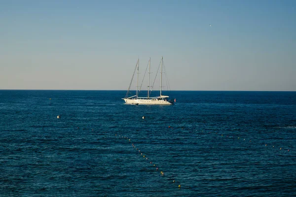 Racing yacht in the Mediterranean sea on blue sky. The boat floats on the water.