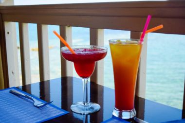 Tablo, deniz arka plan üzerinde iki egzotik kokteyller