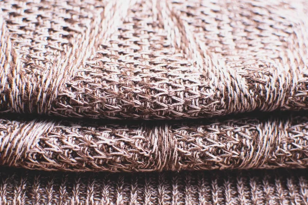 Knitted brown sweater texture. Brown texture with cable pattern.