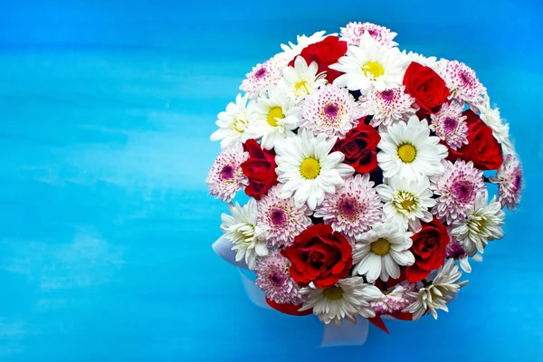 stock image Beautiful red roses and delicate chrysanthemums on blue background.