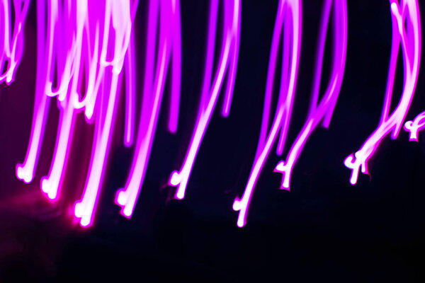 Abstract image of neon pink lights on a dark background.