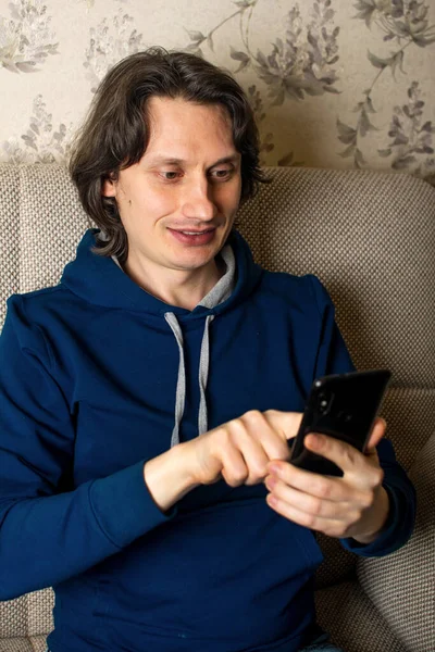 Junger Mann bestellt mit Smartphone im Online-Shop. — Stockfoto