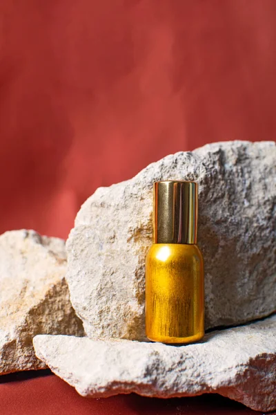 Butelka perfum na brązowym tle i kamienie naturalne. Kosmetyk naturalny. — Zdjęcie stockowe