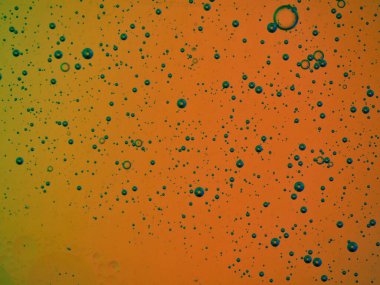 bubbles blowing up into a tough substance with a colored background