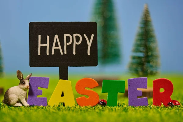Mutlu Paskalya arkaplanları, çimenlerin üzerinde tavşancıklar, 3D harfler.