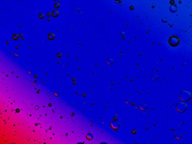 bubbles blowing up into a tough substance with a colored background