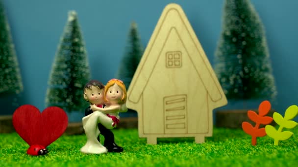 Nahaufnahme Der Figur Des Ehepaares Und Des Holzhausmodells — Stockvideo