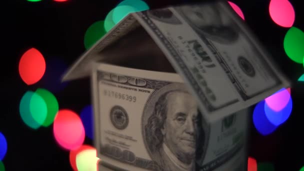 Nahaufnahme Des Rotierenden Hauses Aus Dollars Auf Buntem Bokeh Hintergrund — Stockvideo
