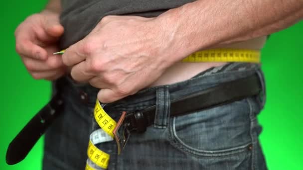 Cropped Shot Man Measuring Waist Yellow Tape Green Background — Stock Video