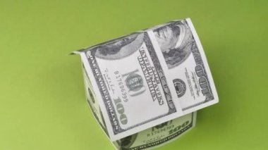 Evin yeşil arka planda dönen dolarlardan yapılmış yüksek açılı görünümü