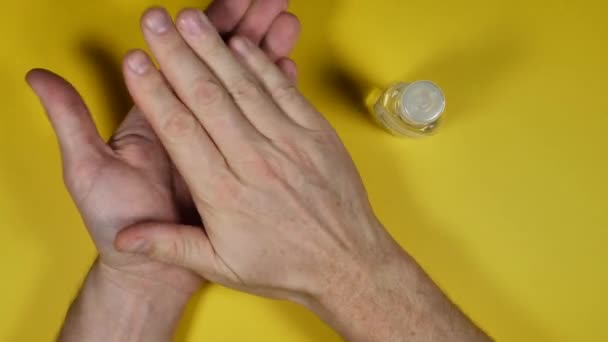 Teilansicht Der Person Die Hände Mit Desinfektionsmittel Auf Gelbem Hintergrund — Stockvideo